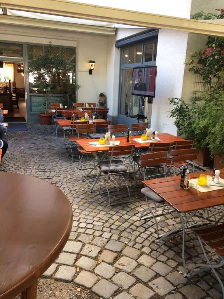 Familien und Freunde genießen im Biergarten des Restaurant Olympia griechische Spezialitäten